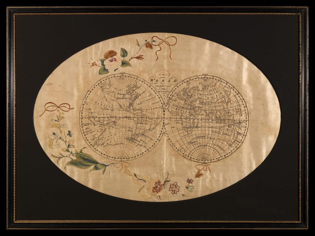 Double planisphère brodé avec des Fleurs décoratives autour. Au centre le texte : "THE WORLD with all the Modern DISCOVERIES"."