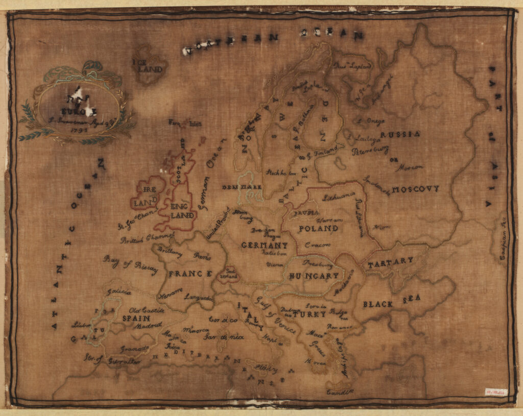 Carte brodée représentant les territoires européens jusqu'aux frontières d’Asie et d'Afrique. Les pays ou régions ont leur nom brodé à l'intérieur, tout comme les mers et les océans.