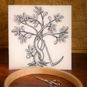 Broderie au fil noir sur toile blanche dans le style des gravures de la renaissance. Un figuier avec des feuilles et des fruits, des troncs et des branches entrelacées. Une faux est posée contre le tronc.
