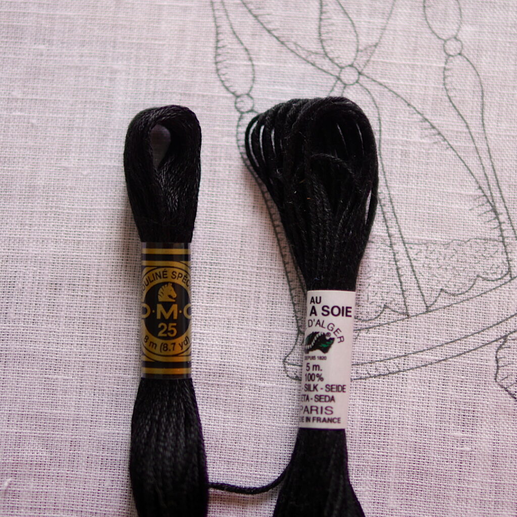 Gros plan sur la toile imprimée avant la broderie, on voit que tous les points sont imprimés à l'encre grise. Par dessus, il y a 2 échevettes de fil noir : une de coton DMC, une autre de soie d'Alger Au vers à Soie.