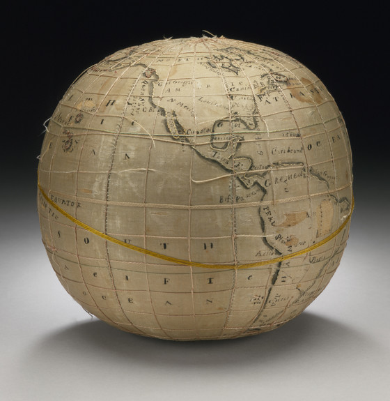 Un globe terrestre ancien en soie. Il y a des cordes autour, les textes et certaines informations sont imprimées. Les côtes sont brodées.