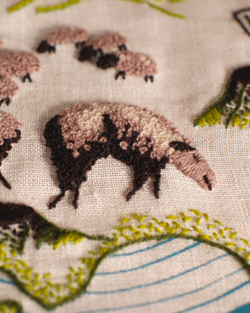 Les moutons sont brodés en brun-rose, marron et beige avec un point qui forme des petits nœuds bouclés.