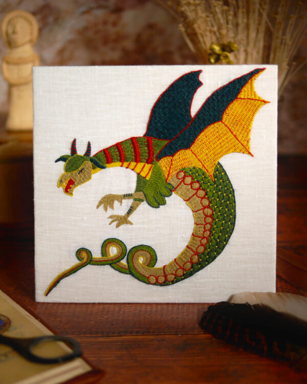 Enluminure dans une marge où un dragon noir est de profil, perché sur un monticule d'herbe et crache du feu le cou tendu.