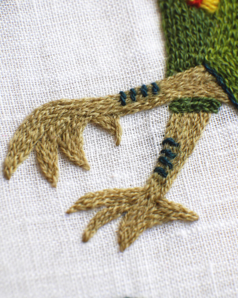 Détail de la broderie des pattes du dragon en vert kaki. Elles sont formées de 4 griffes un peu comme des pattes de poules (oui bon, de suite, c'est moins terrifiant).
