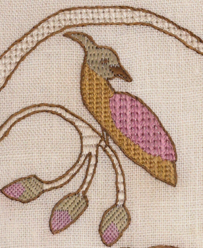 Gros plan sur la broderie de la huppe fasciée brodée en jaune vert et rose. Elle est perchée sur des bourgeons de rose.