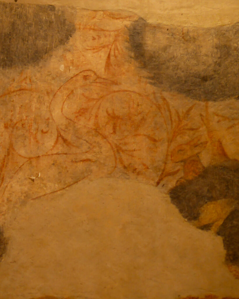 Une fresque très abîmée sur mur clair. au milieu d'arbres, un cygne et un lapin.