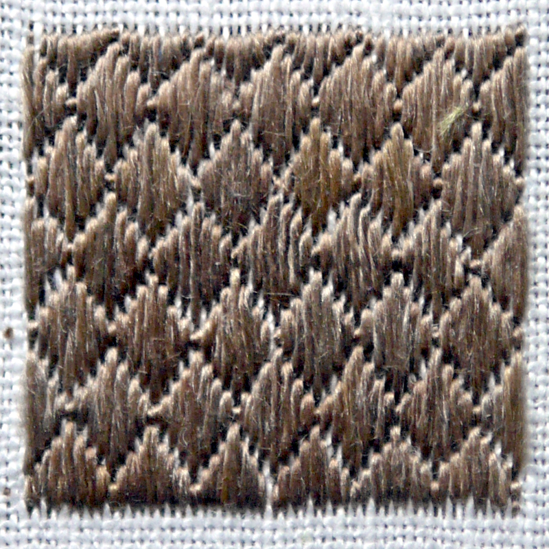 Petit carré brodé en marron avec des points droits parallèles qui forment des losanges.